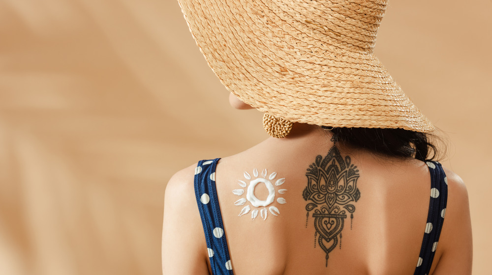 Woman in beach hat with lotion