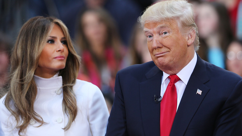 Melania Trump looking at a surprised Donald Trump