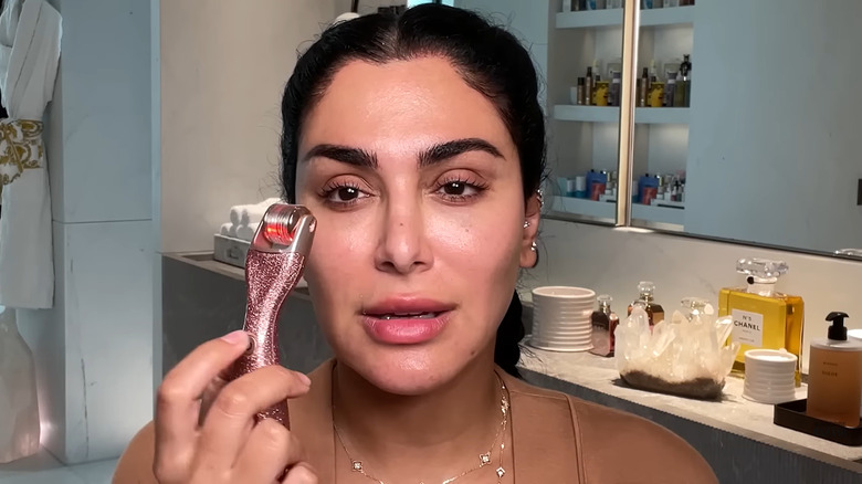 Huda Katan using a derma roller on her face