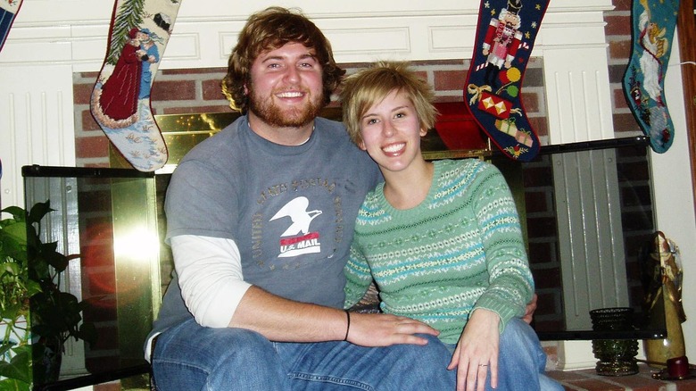 Young Ben and Erin Napier posing by fireplace