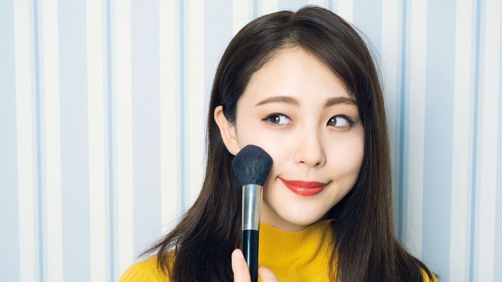 A woman with a foundation brush