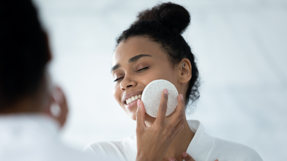 A woman exfoliating her face