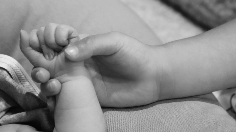 Wolf Webster and Stormi Webster holding hands