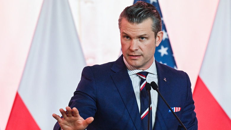 Pete Hegseth in navy suit and flag pocket square