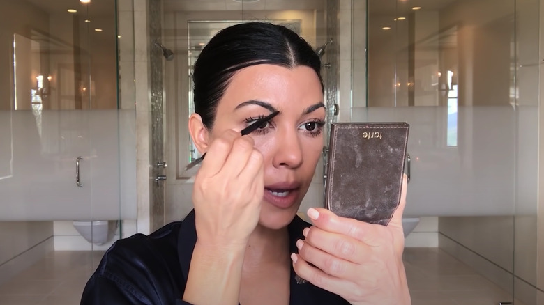 Kourtney Kardashian putting on brow product 