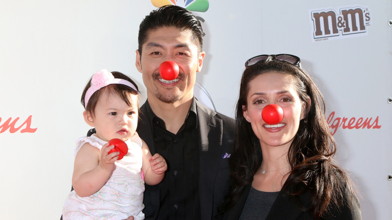 Brian Tee with wife and daughter wearing red noses at event