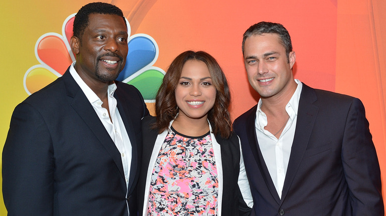 Eamonn Walker, Monica Raymund and Taylor Kinney smiling together at an event