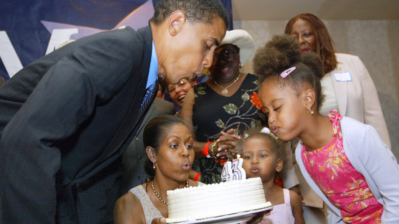 The Obamas blowing out birthday cake candles