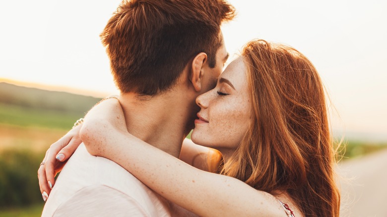 red headed woman hugging man in street