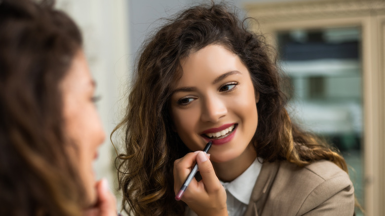 Woman applying lip liner 