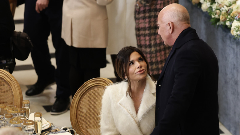 Lauren Sánchez sitting while Jeff Bezos stands over her