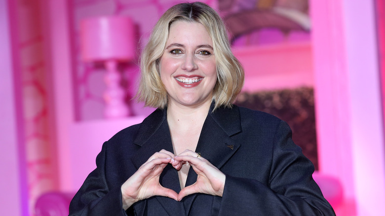 Greta Gerwig making a hand heart