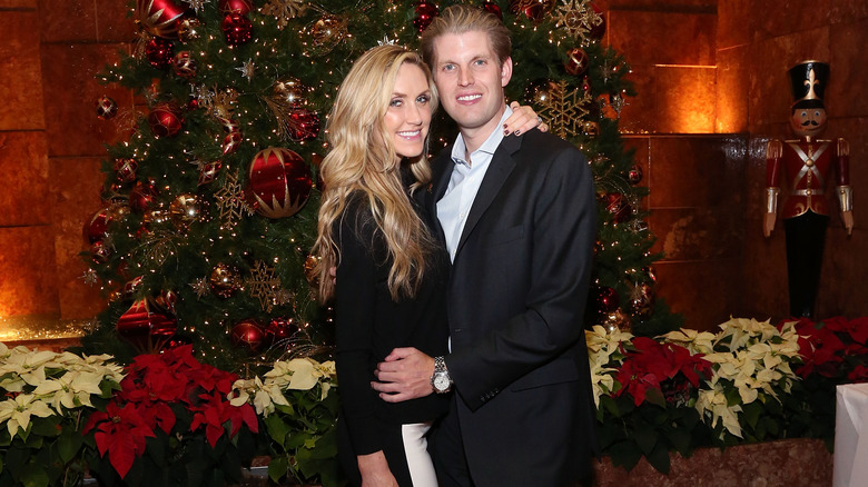 Eric and Lara Trump posing in front of Christmas tree