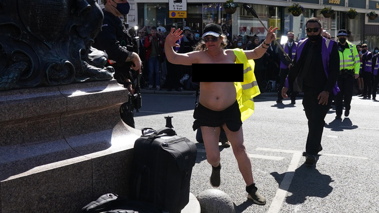 Protestor running topless. 