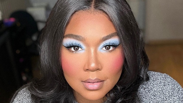 Lizzo looking at camera with blue eyeshadow