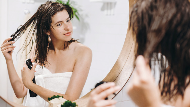 Woman applying product to wet hair