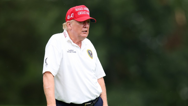 Donald Trump in polo and MAGA hat