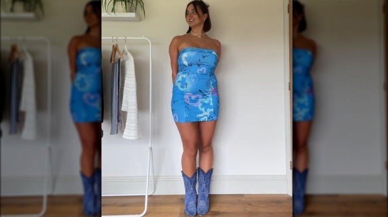 A woman wearing a tube dress and cowboy boots