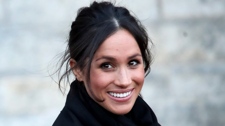 Meghan Markle smiling in black