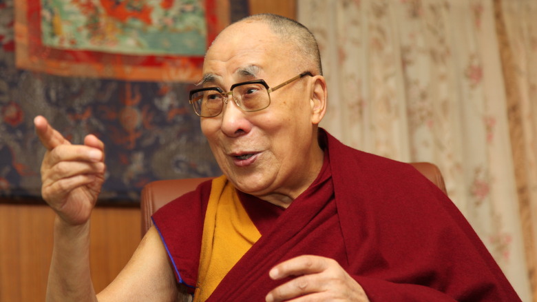 Dalai Lama smiling and pointing