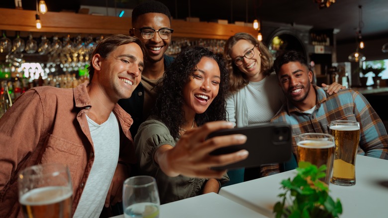 A group of friends taking a selfie at a bar.