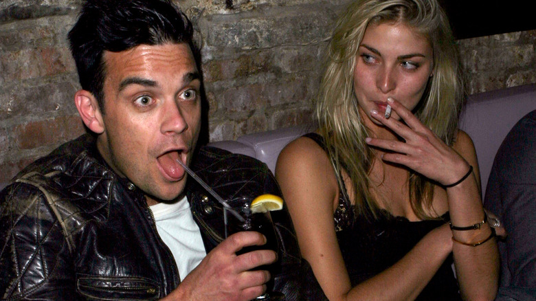 Robbie Williams drinking with a woman