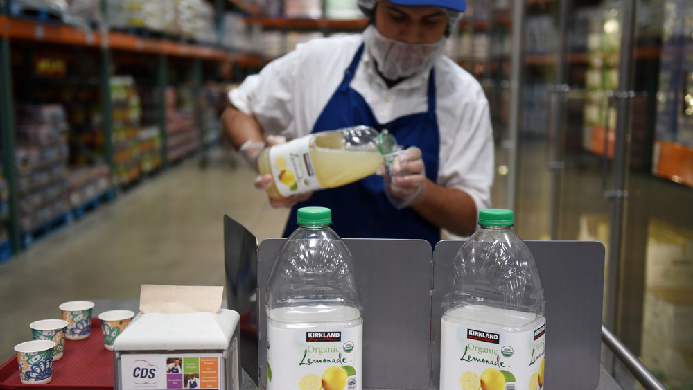 Costco food demonstrator filling cups for free samples