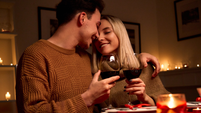 couple cuddling and drinking wine