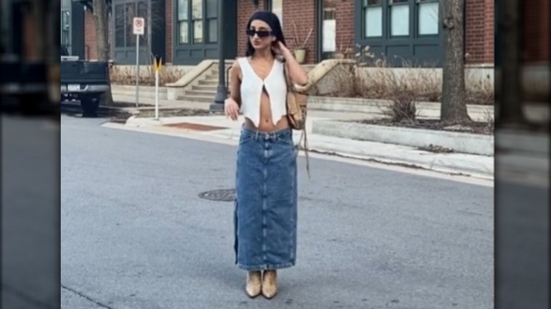 A woman wearing a crop top and maxi skirt