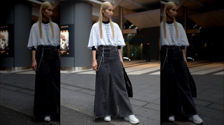 A woman wearing a tee shirt and maxi skirt