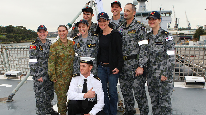 Pauley Perrette posing with navy officers 