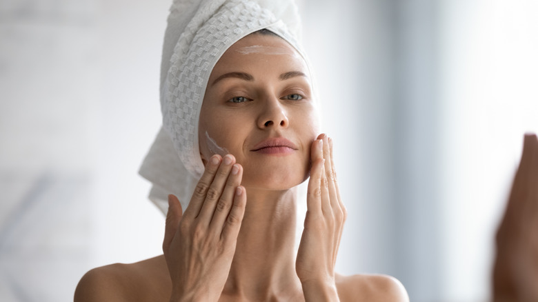 Woman cleansing face after shower