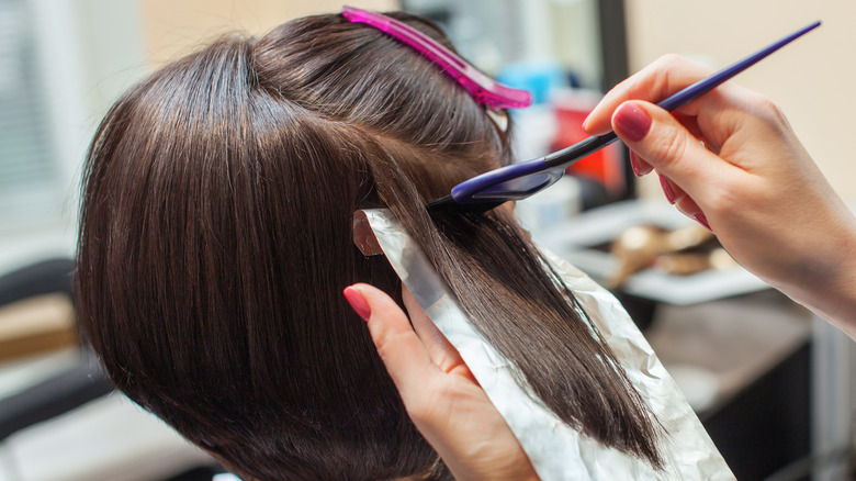 Woman getting hair highlights