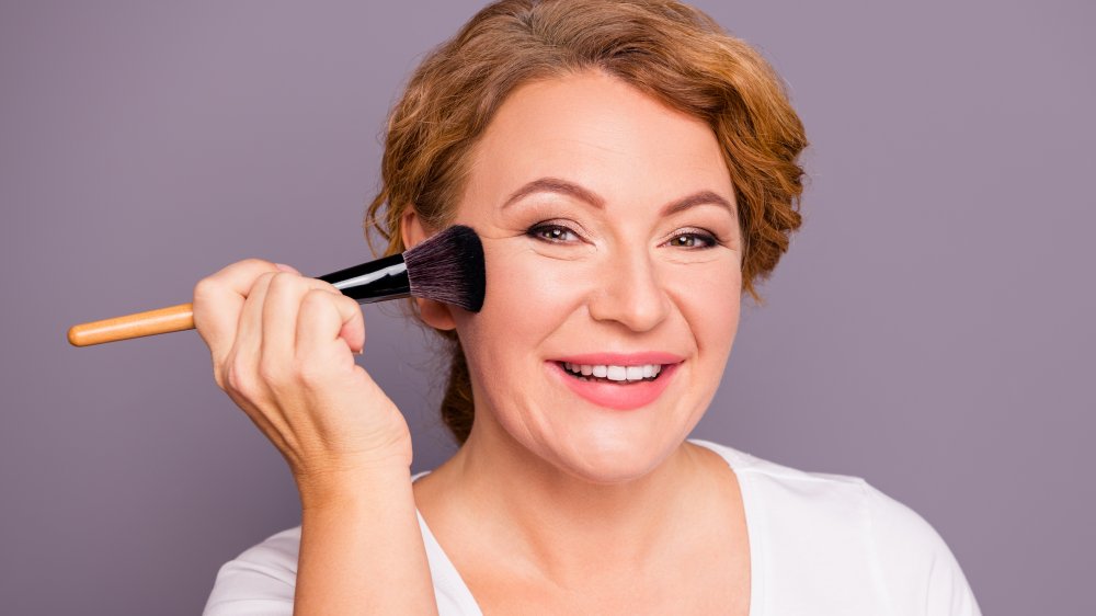 woman with makeup brush and wrinkles