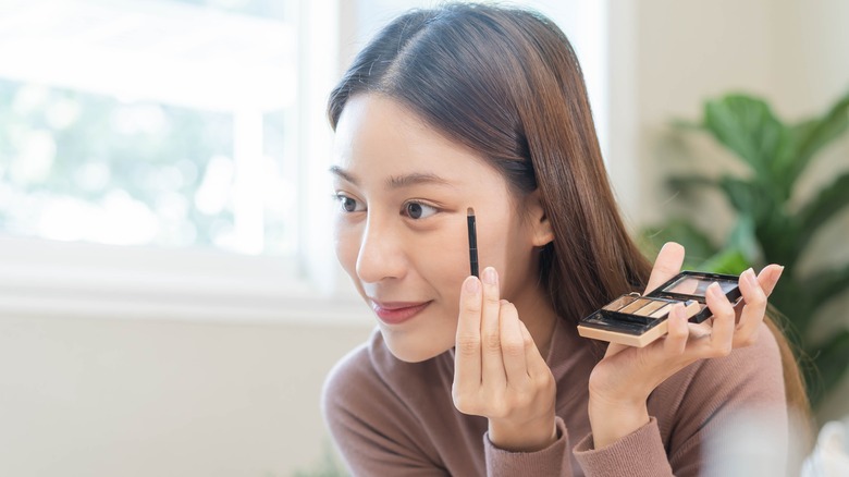 A woman applying eyeshadow