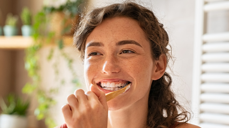 Young woman brushes her teeth 