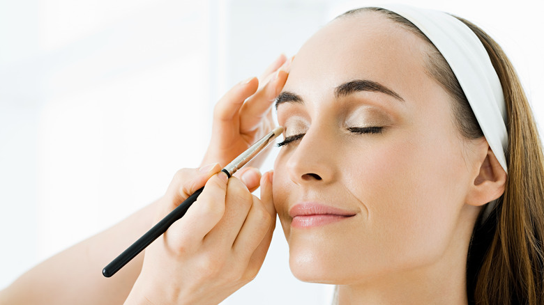 Woman getting her makeup done.