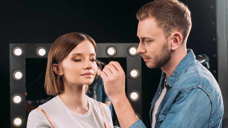 Makeup artist and young woman. 