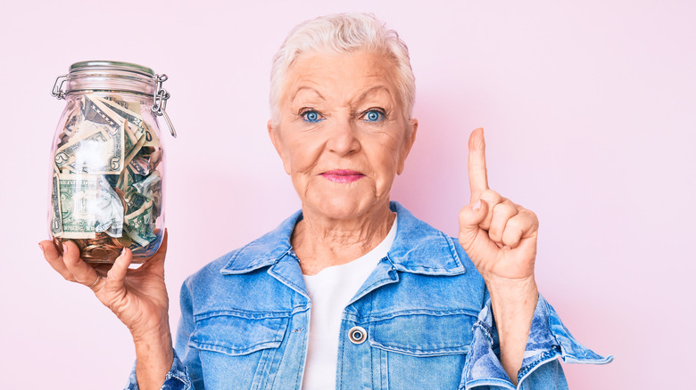 Senior woman holding tip jar 