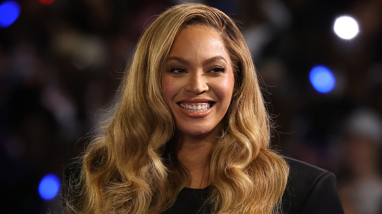 Beyoncé smiles onstage while at a political rally for Vice President Kamala Harris