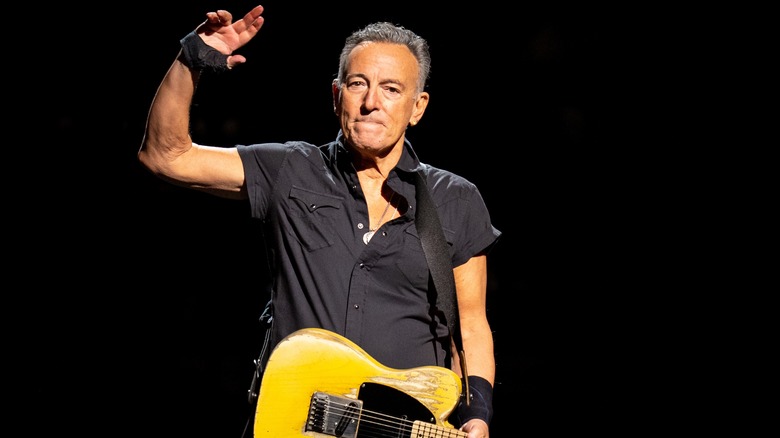 Bruce Springsteen with guitar raising hand