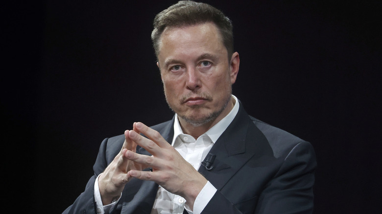 Elon Musk looking deep in thought in a suit