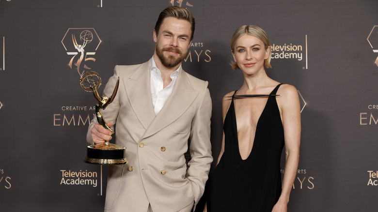 Julianne Hough and Derek Hough posing with an Emmy statue