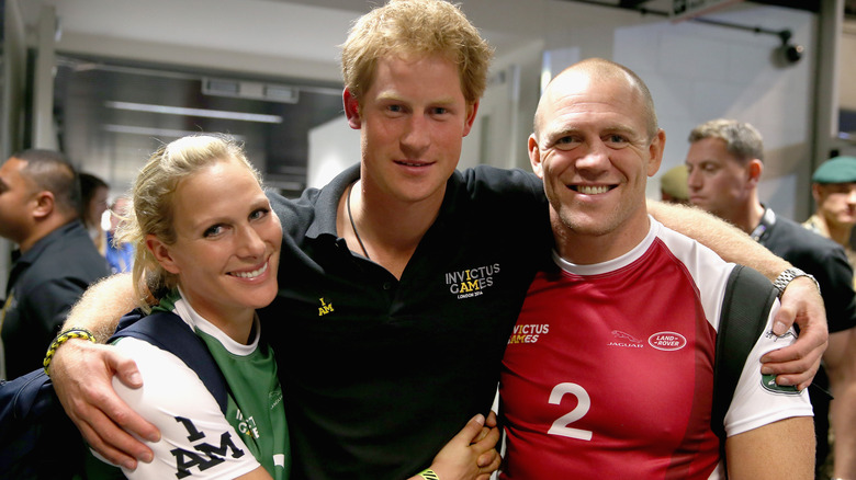 Zara Tindall, Prince Harry, and Mike Tindall posing for a photohraph