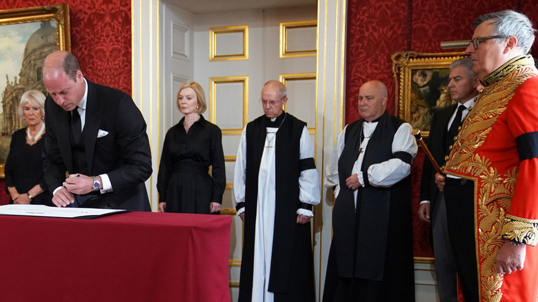 Duke of Norfolk watching Prince William sign proclamation of accession