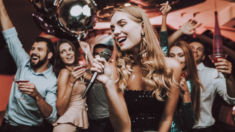 Group of people singing karaoke at party