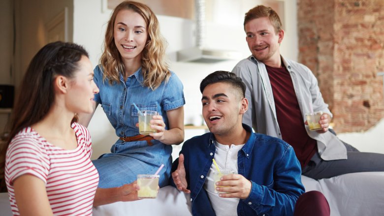 Two charming couples drinking and chatting on a sofa