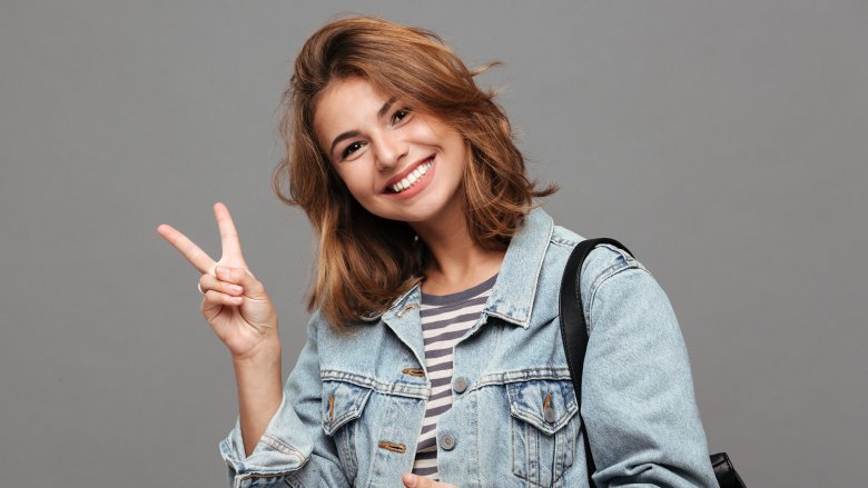 Charming woman giving peace sign