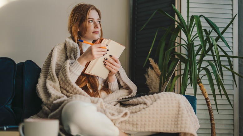 A woman sitting with a journal