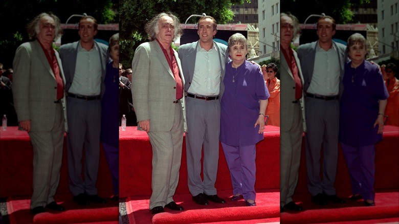 Nicolas Cage posing at his Walk of Fame induction with his parents in 1998